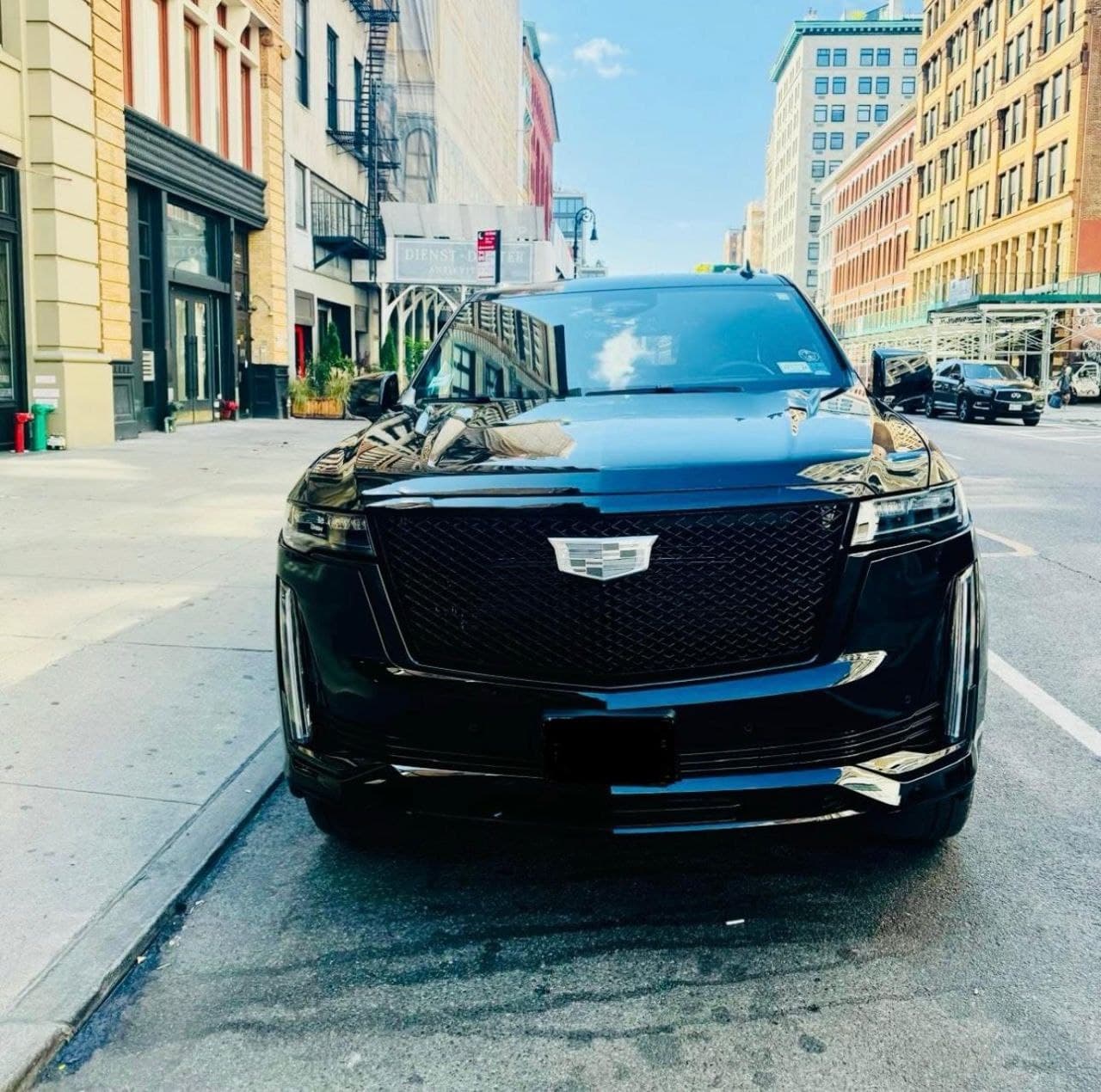Black Cadillac SUV on palm tree-lined street